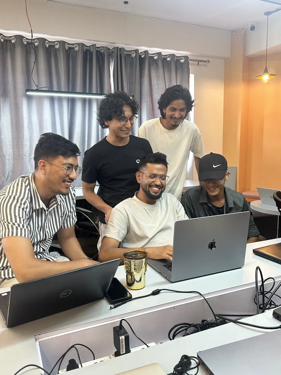NepalHRM developers collaborating around a laptop while building the HRMS platform