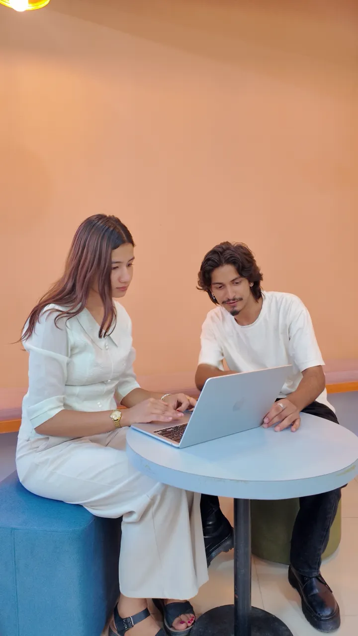 Two NepalHRM team members working together on a laptop in the office lounge